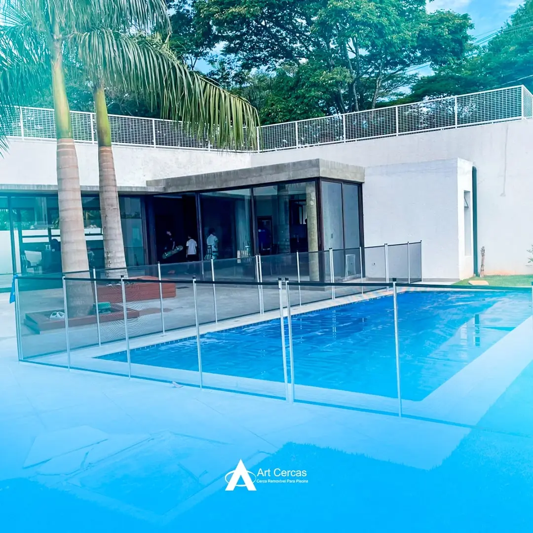 Cerca de proteção removível ao redor de piscina retangular em casa moderna com palmeiras