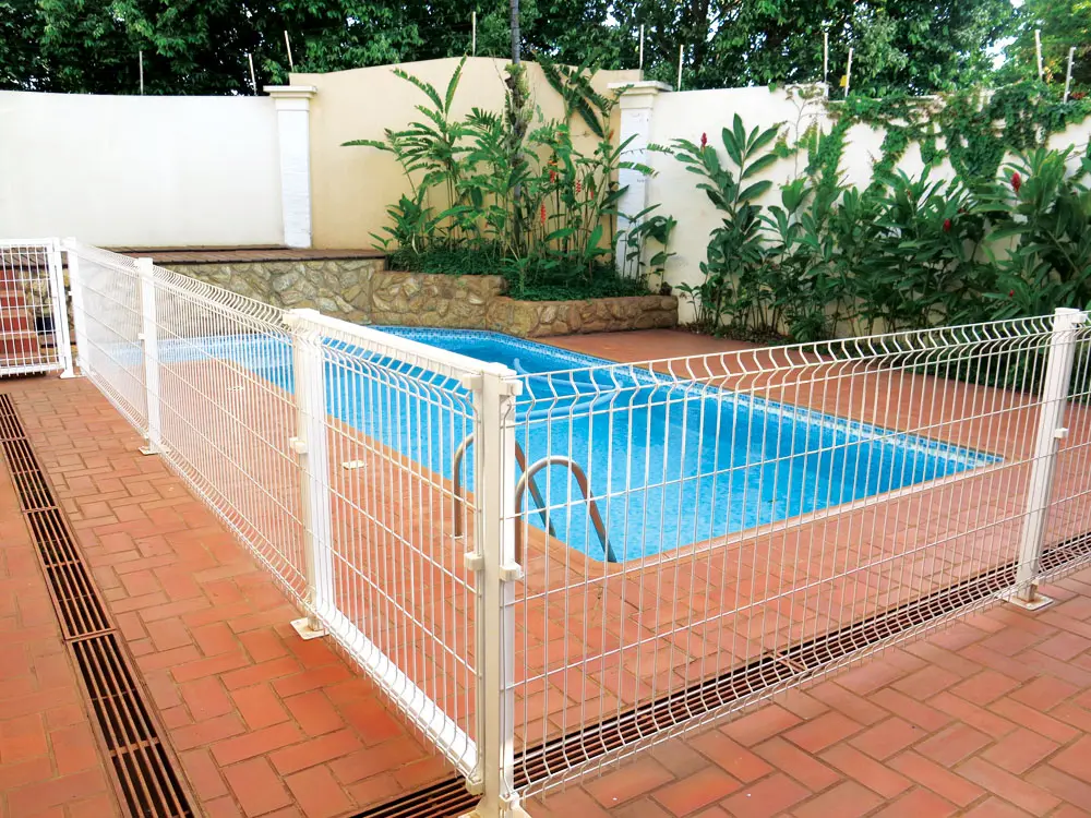 Gradil fixo branco em volta de piscina residencial com piso de cerâmica