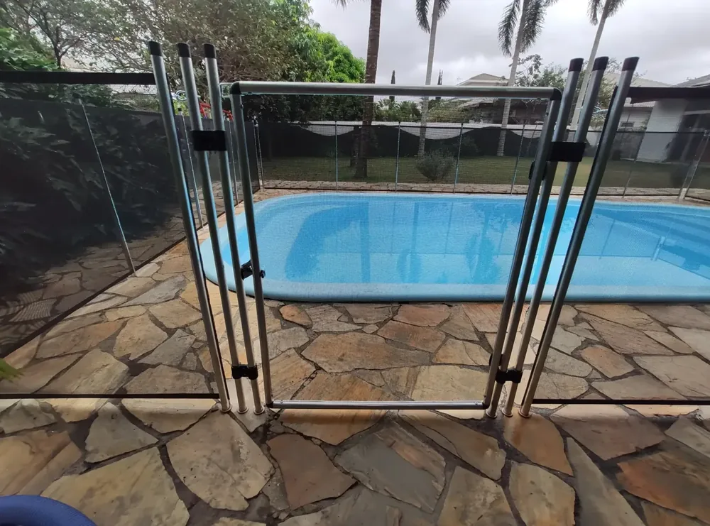 Portão de cerca removível para piscina instalado em piso de pedra natural